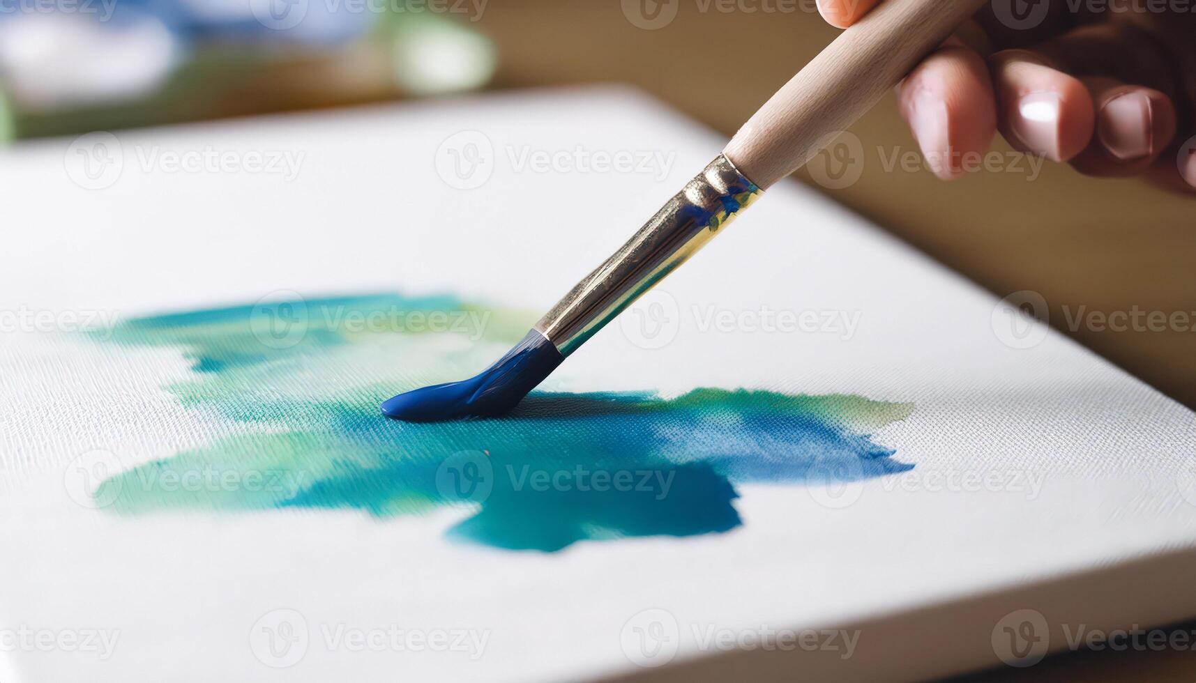 Closeup of a brush with blue paint on a canvas photo