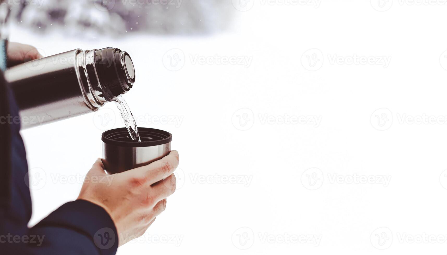 Pouring Hot Drink From Thermos Into Cup photo