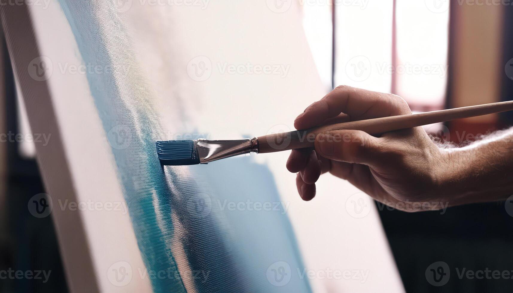 Close up of hand painting with a brush on a canvas photo