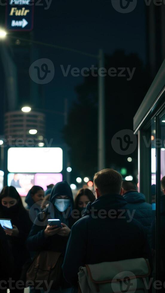 People waiting at a bus stop at night photo