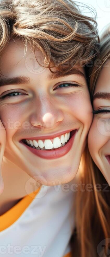 Closeup portrait of a young man smiling with a woman's shoulder peeking out in the background photo