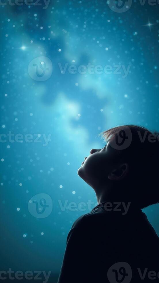 Young boy gazing at the starry night sky photo