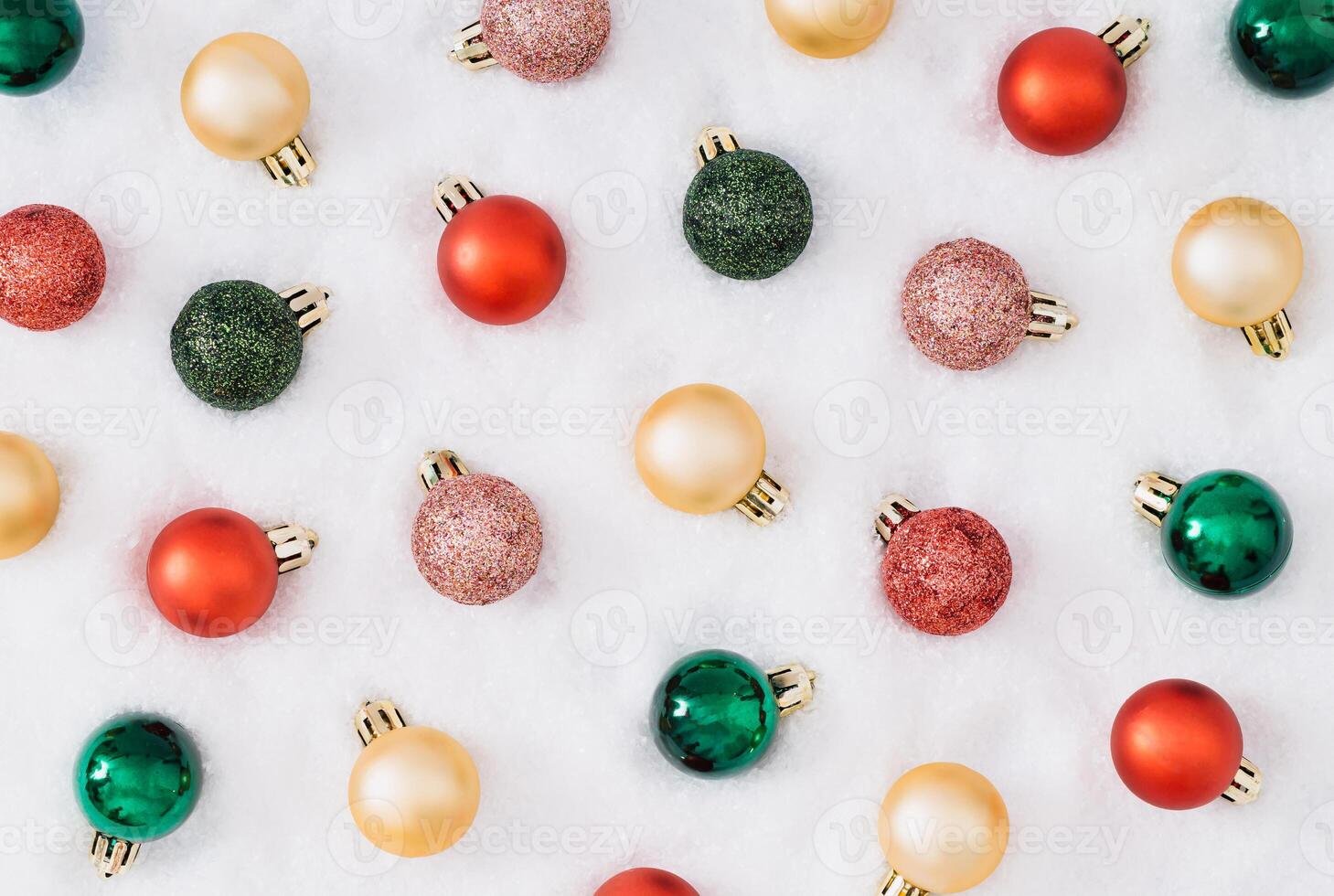 Trendy Christmas pattern composition made with colorful Xmas baubles on snowy background. Minimal Christmas and New year concept. Creative festive winter holiday pattern backdrop. Flat lay. photo