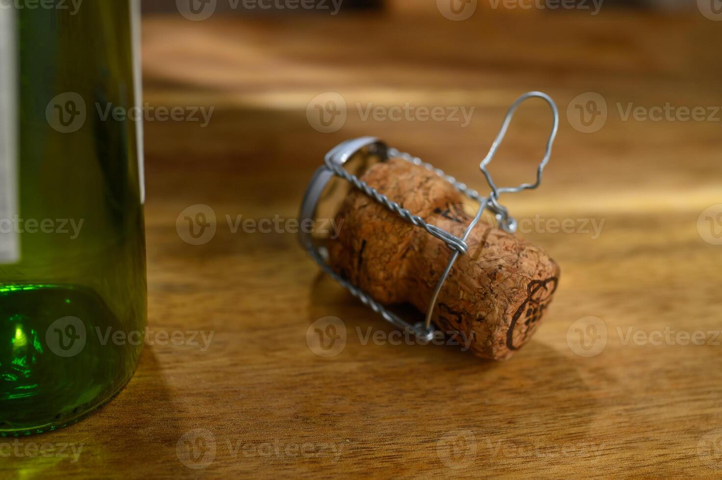 One champagne cork and a ray of light, on a wooden table on a white background photo