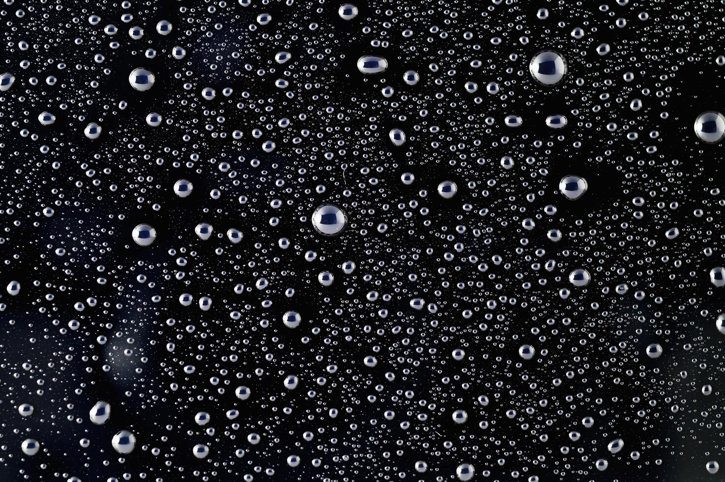 Drops of water on a black surface. The condensate. Top view. Free space. photo