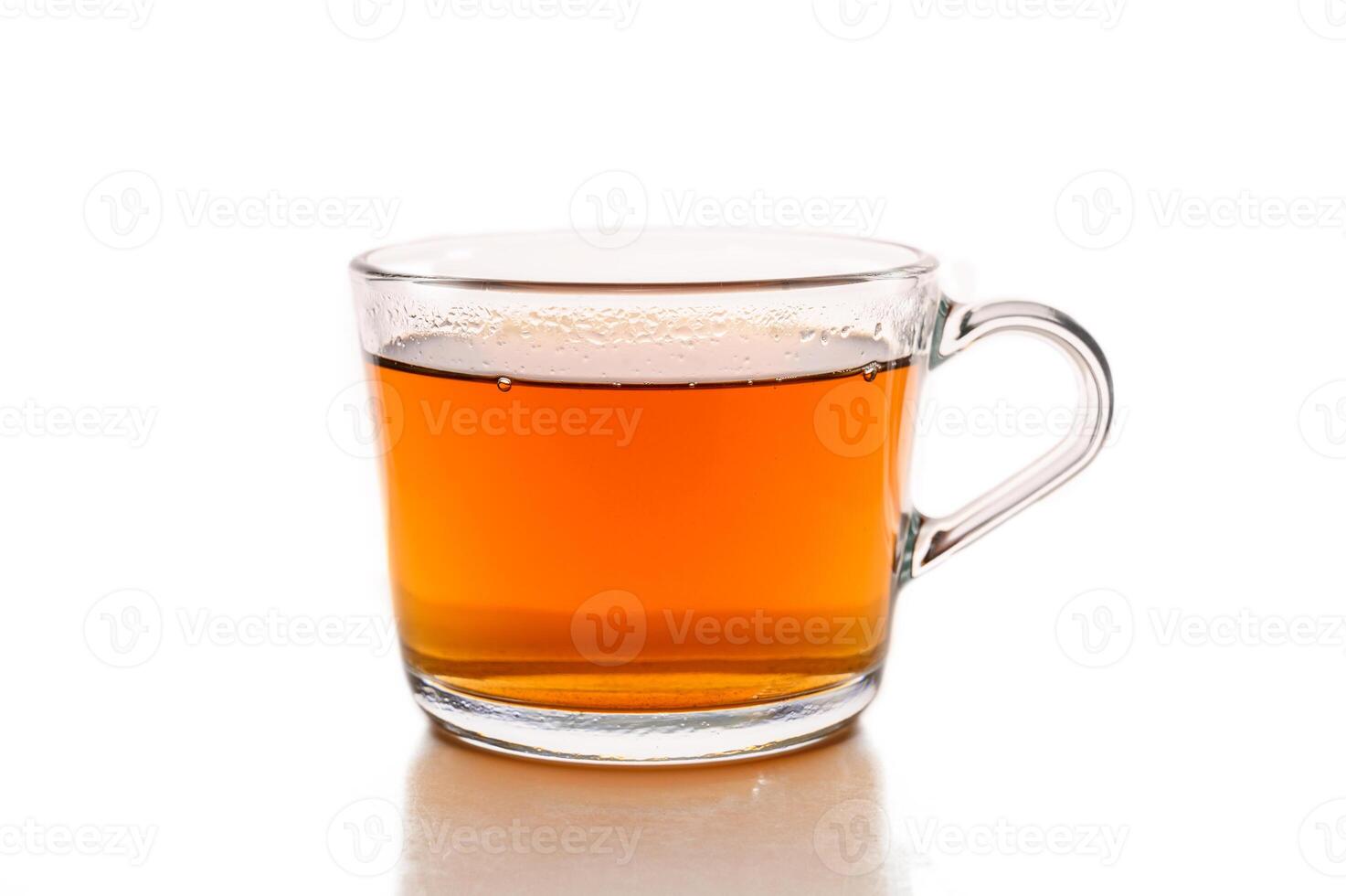 Glass cup of hot aromatic tea on white background photo
