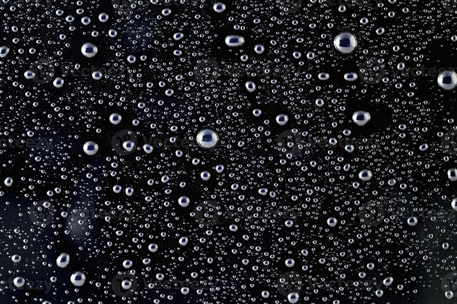 Drops of water on a black surface. The condensate. Top view. Free space. photo