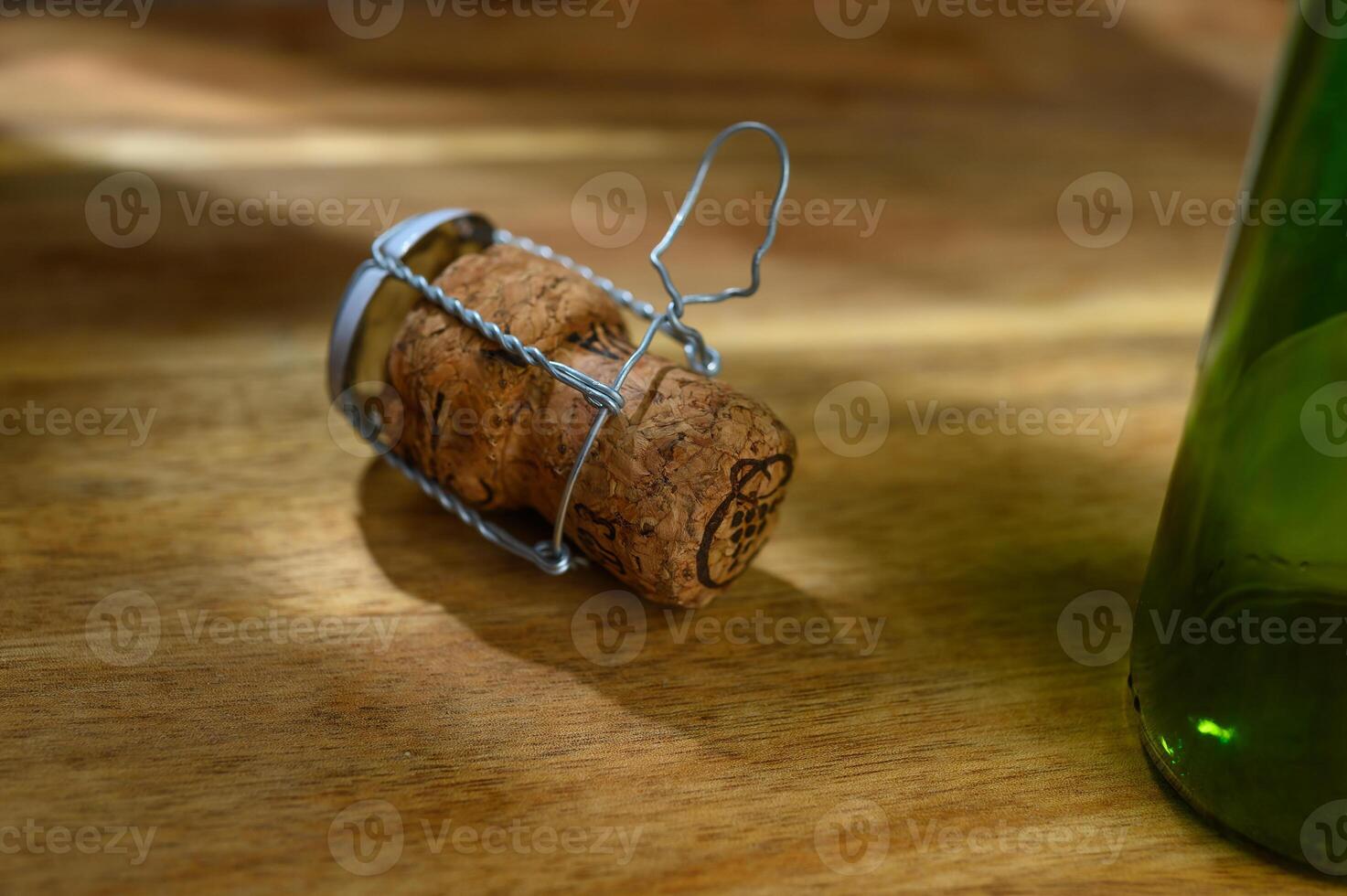 One champagne cork and part of a bottle, on a wooden table on a white background photo
