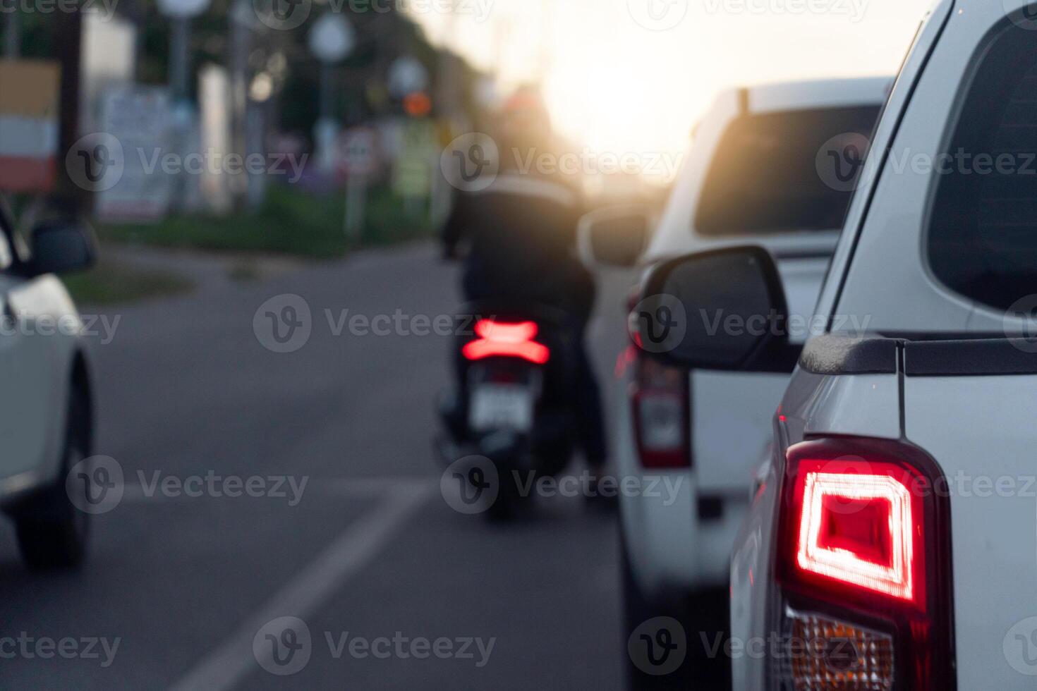 Rear side of white pickup car on the aspahlt road. Transtport of car turn on brake light in the business time environment of moring time. Traffic congestion and queues of cars. photo