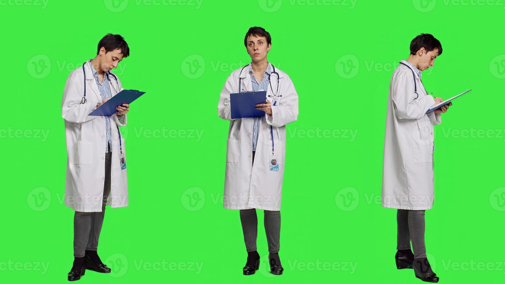 Physician taking notes after patient examination against greenscreen backdrop, writing down medicaments to cure illness. Doctor in white coat using clipboard papers for checkup. Camera A. photo