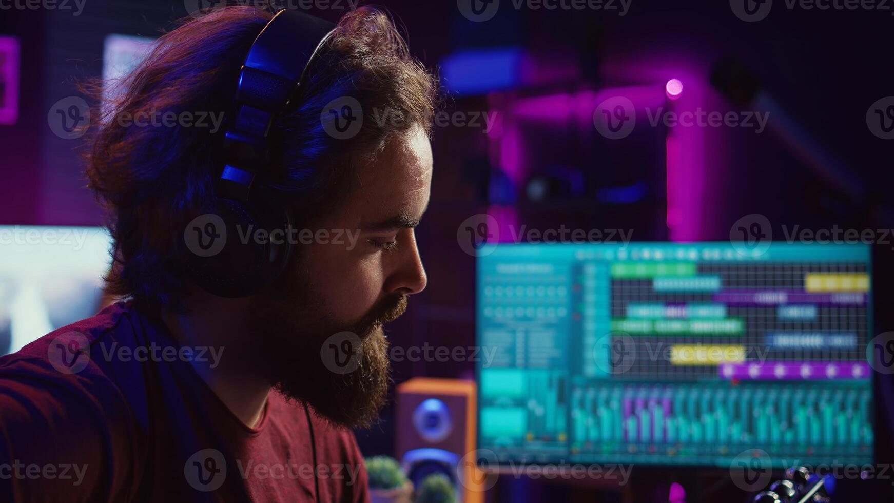 Professional songwriter playing guitar and using soundboard for mixing and mastering tracks. Producer composing a song with audio equipment at home recording studio, equalization tools. Camera B. photo