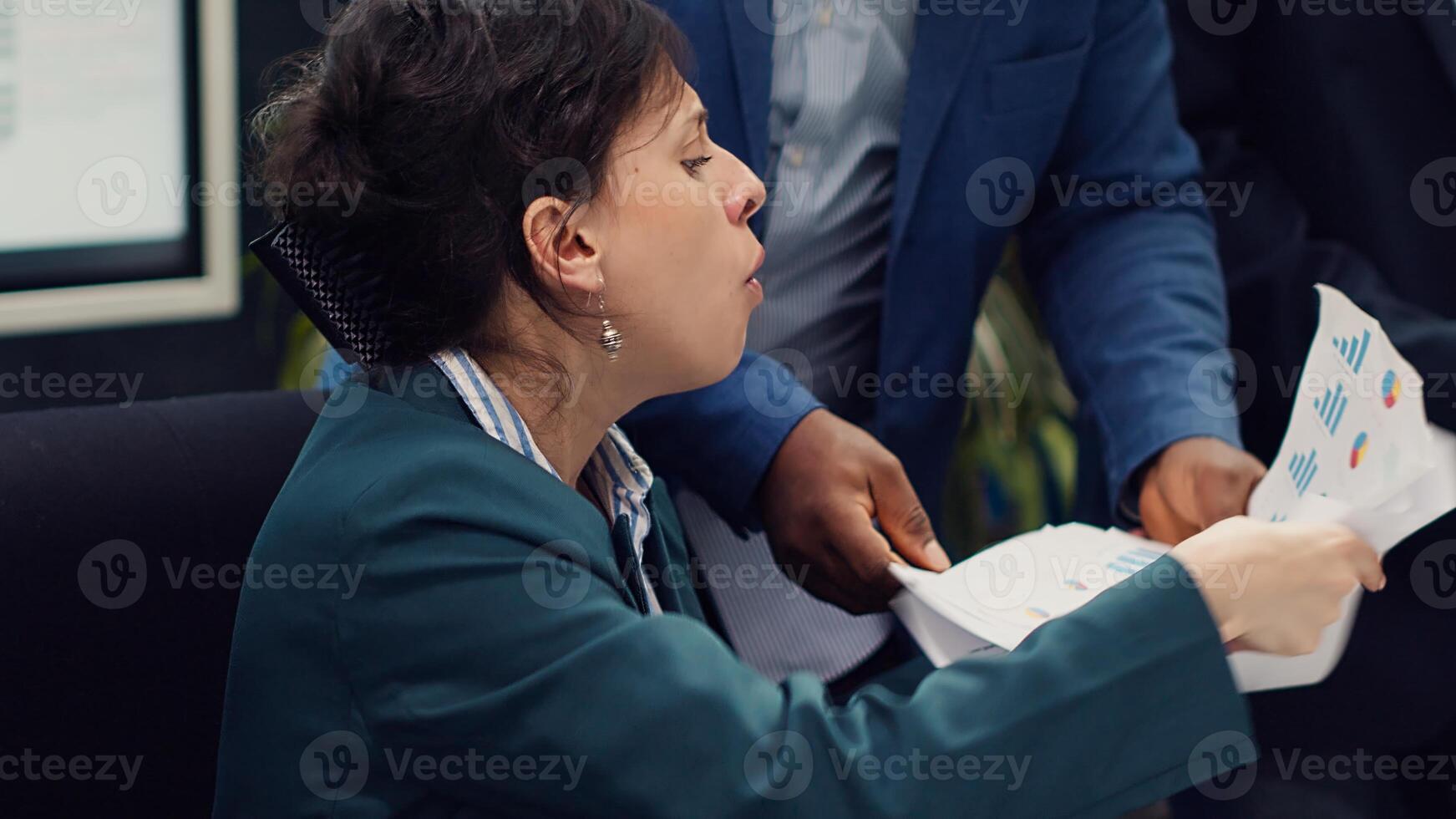 Irritated difficult boss getting angry at her employees team after not finishing the project before the deadline. Crazy manager yelling at her staff members and throwing papers. Camera A. photo