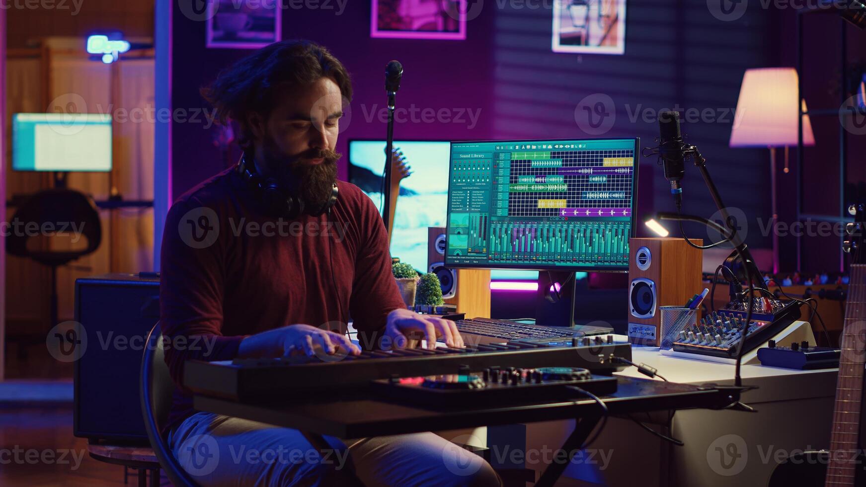 Sound engineer playing electronic piano keyboard and recording sounds, using mixing console and daw software to create new tunes. Music industry specialist uses stereo tools at home studio. Camera A. photo
