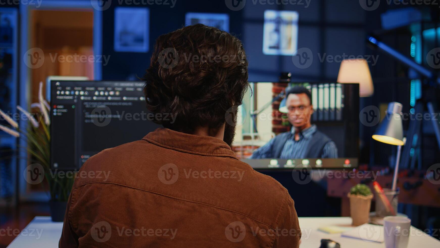 Remotely working software developer talking with manager during online videocall, updating him on programming task progress. IT specialist in teleconference meeting with team leader, camera B photo