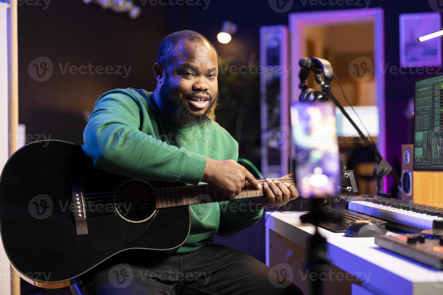 Guitarist instructor hosting guitar lessons online using a mobile phone, recording tutorial for master class. Artist musician explaining acoustic instrument accords, assistance for beginners. photo