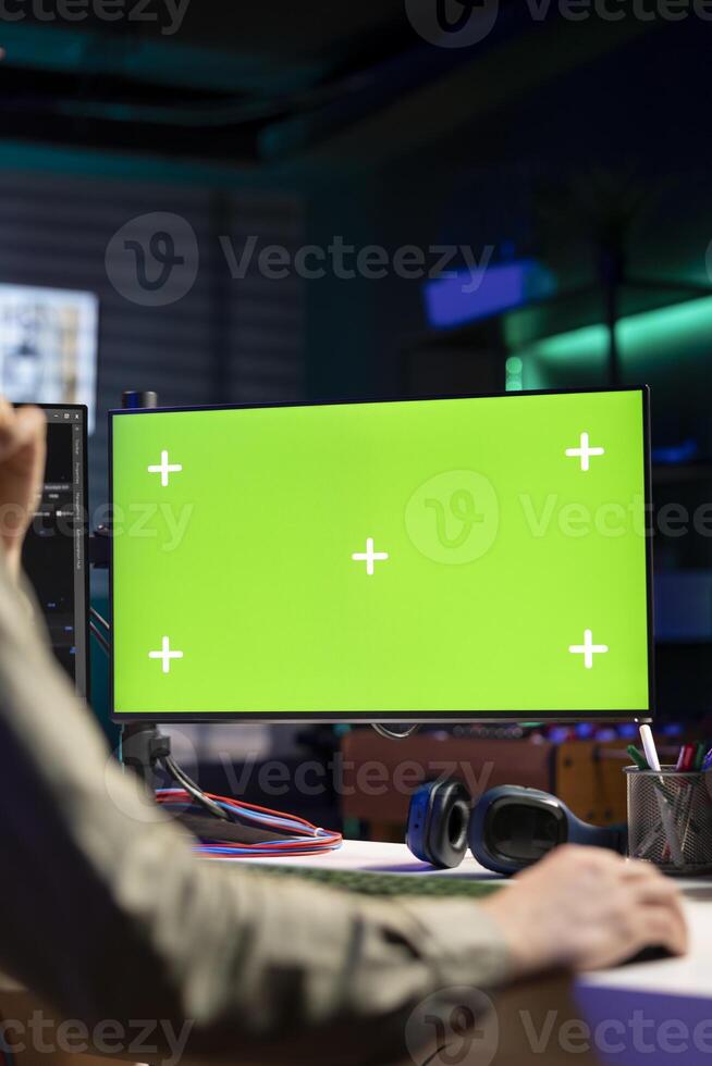 Man using isolated screen PC monitor to update artificial intelligence neural networks, writing binary code script. IT professional upgrading high tech AI using chroma key computer, close up photo