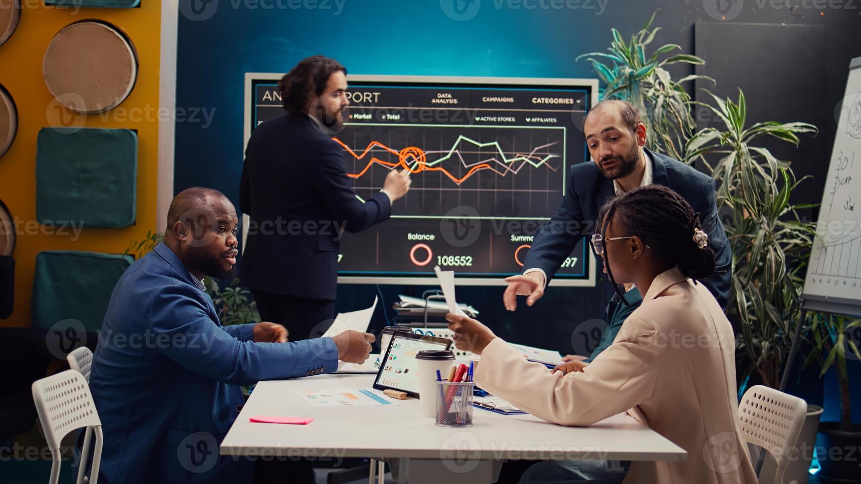 Project managers making a presentation with annual reports to evaluate statistics and understand what can be improved, problem solving meeting. Team identifying issues to ease workflow. Camera B. photo