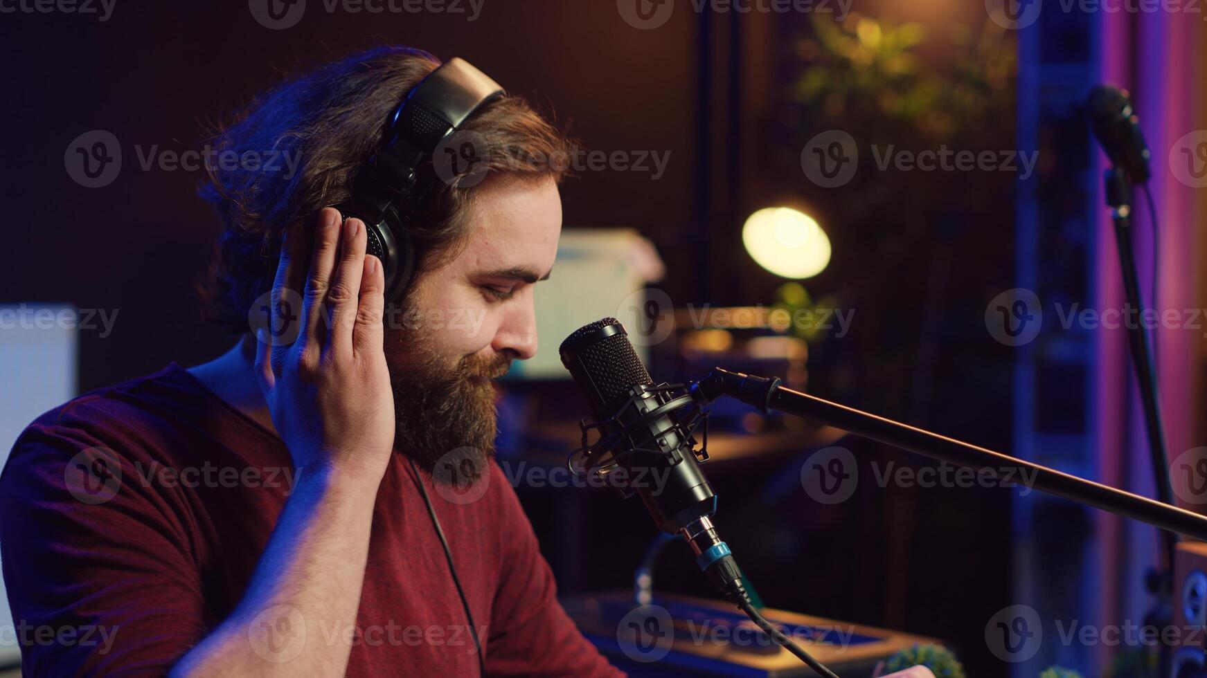 Sound producer recording backing vocals to add over tunes in home studio, using a mixing console to create a modern mix. Music producer mastering a new soundtrack with equalizer tool. Camera A. photo