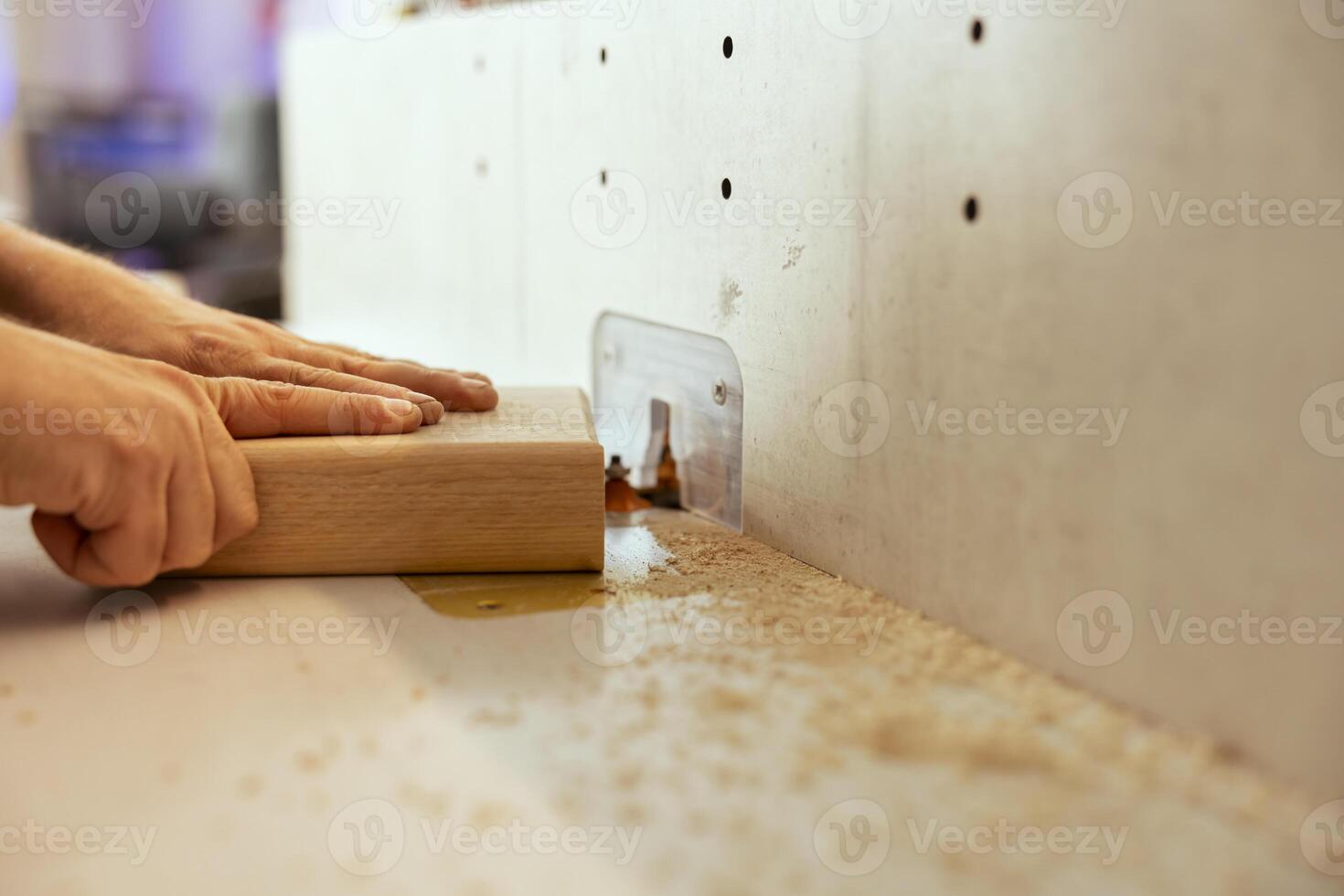Man using wood shaper machinery to finish customer commissioned work on wooden objects in studio. Woodworking specialist in carpentry shop using spindle moulder equipment to do furniture assembling photo
