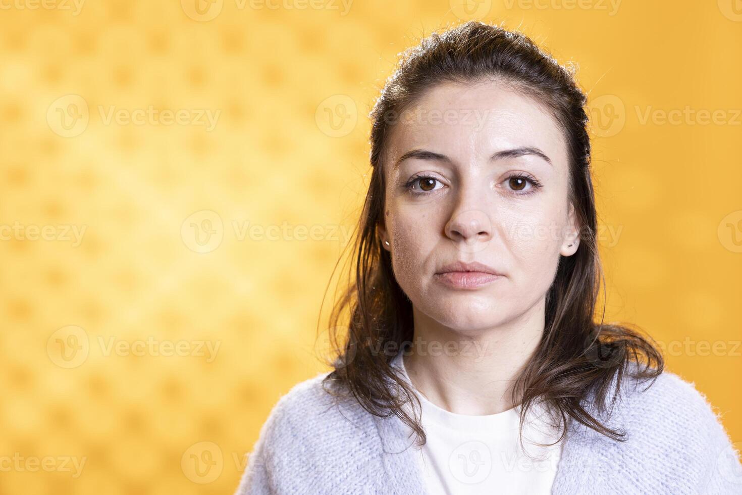 Portrait of optimistic woman posing, feeling happy and relaxed, isolated over yellow studio background. Close up shot of lively radiant caucasian lady standing, looking at camera photo
