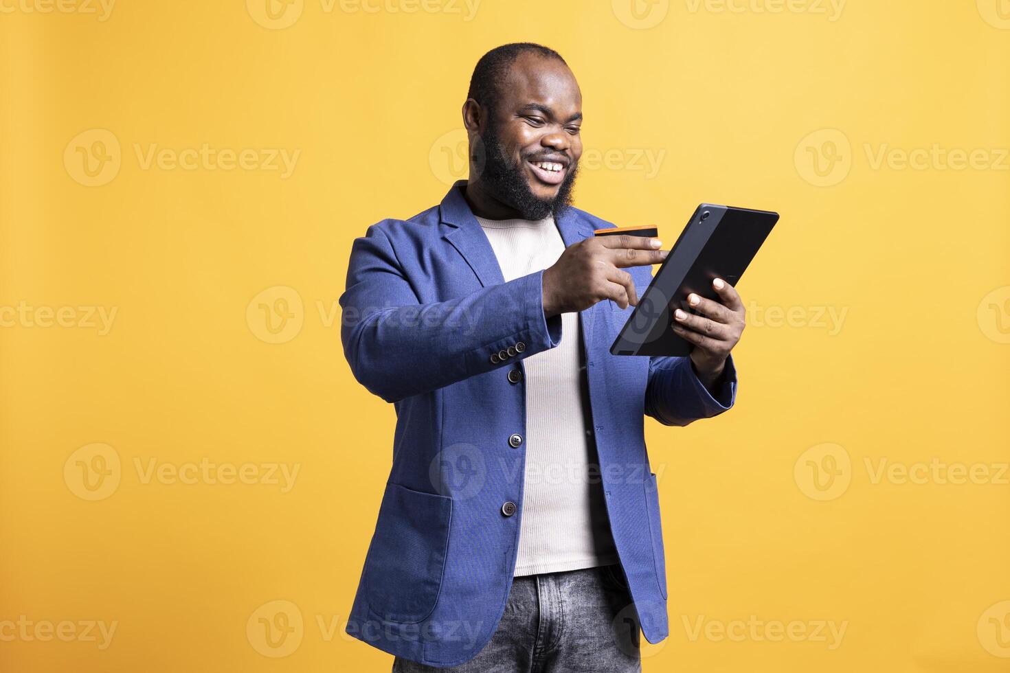 Jolly man adding payment method on website, enjoying himself, isolated over studio background. Happy man excited to do internet shopping, carefully typing credit card information photo