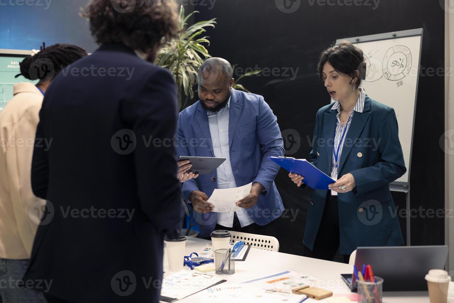 Business partners reviewing latest budgeting plans on papers, organizing a briefing meeting to share ideas and details about updates to ensure progress. Colleagues making decisions for a project. photo