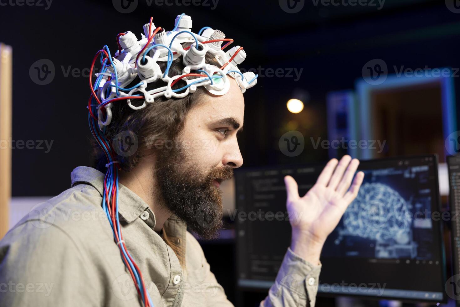 Smiling software technician using EEG headset to upload consciousness into computer. Happy IT admin working with AI, using high tech gear to create connection between brain and PC photo