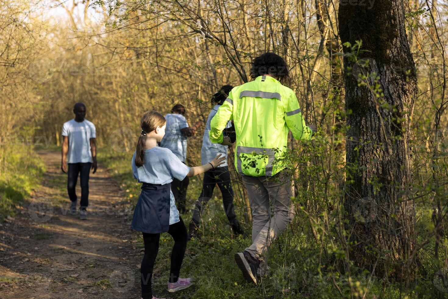 Captain of the rescue party directs his team through the forest to find details during ongoing hunt for a missing person. Voices calling for a civilians name, man lost into the wilderness. photo