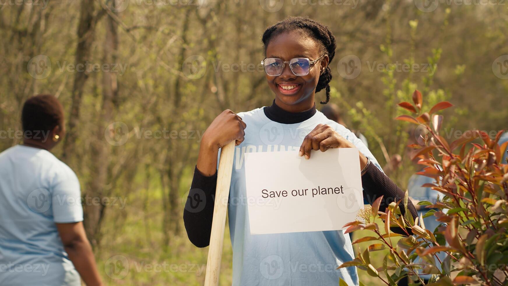 Portrait of african american activist holding poster with save our planet message, spreading environmental care and awareness. Young woman posing with banner to fight ecological justice. Camera A. photo
