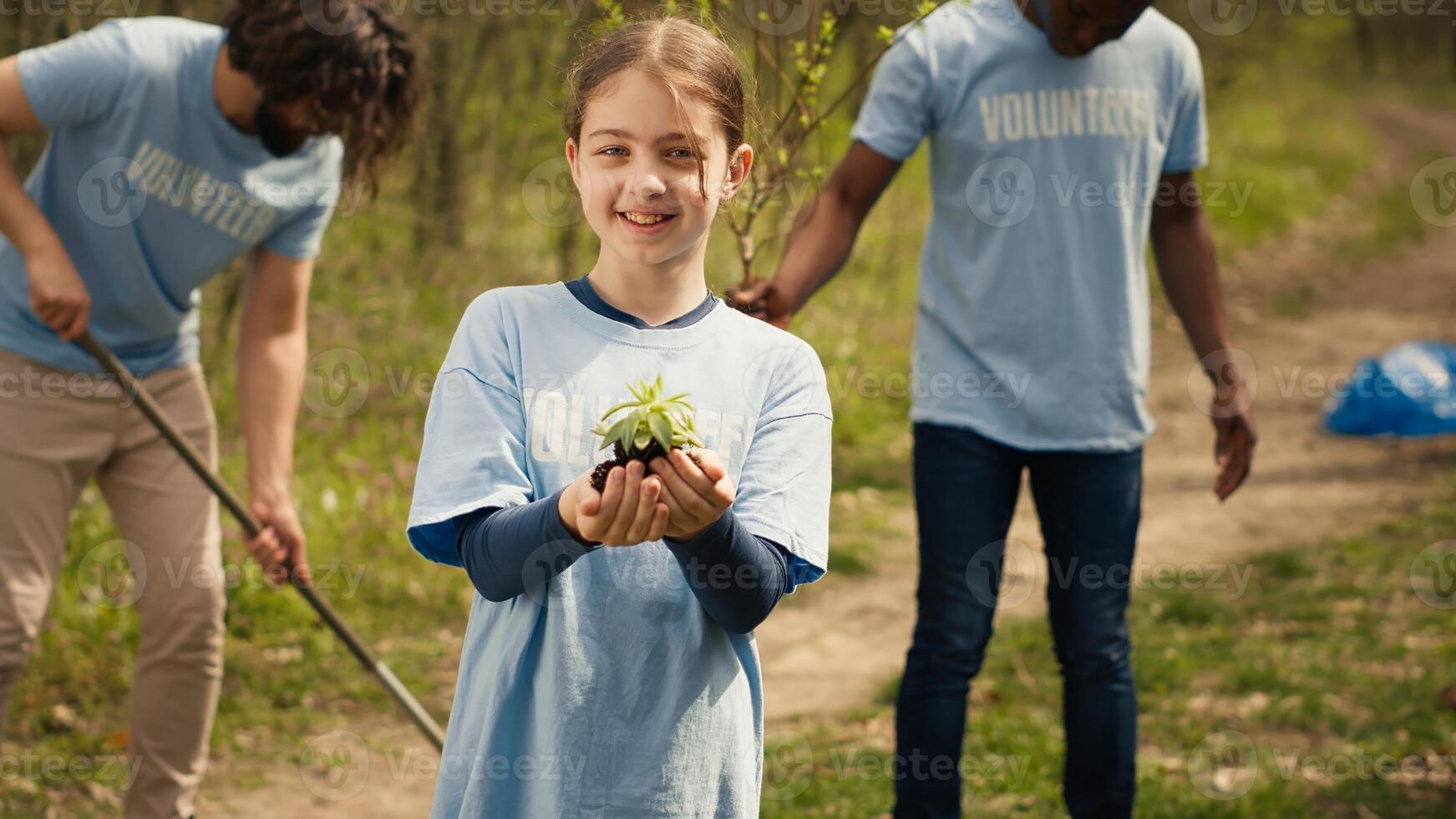 Cute child activist presenting a small seedling tree in her hands, fighting to protect the environment and natural ecosystem. Little girl working to conserve nature and plant trees. Camera A. photo
