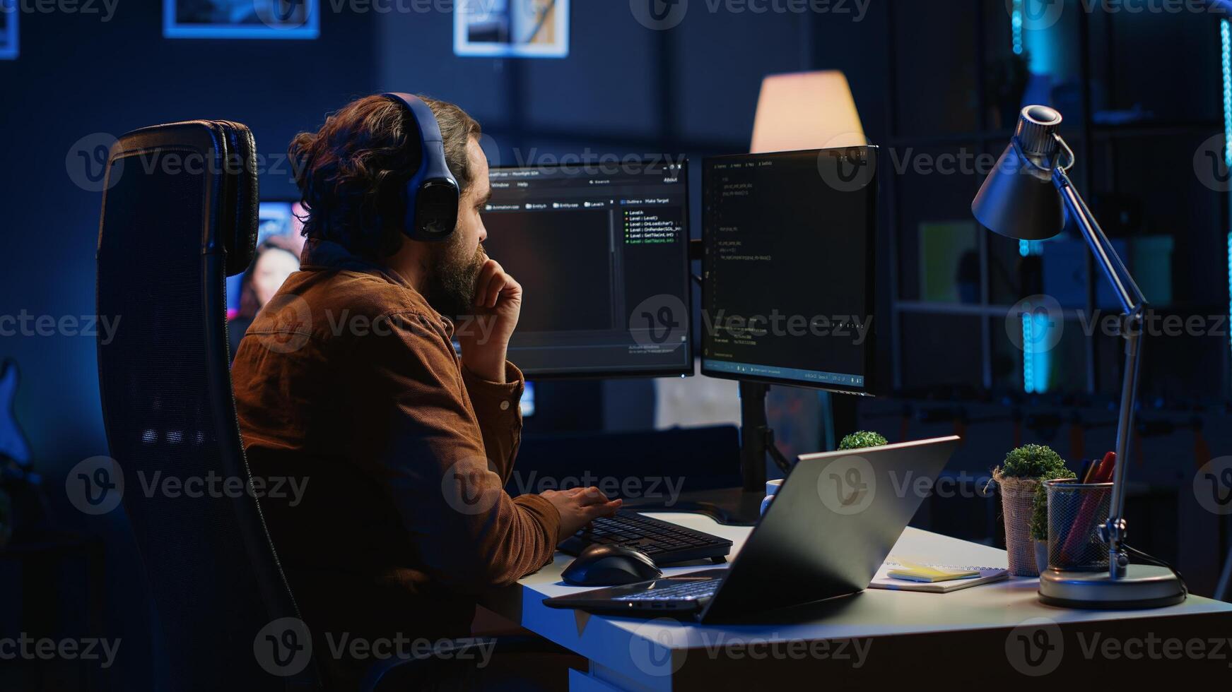 Hyperactive software developer suffering from adhd affliction, writing code, drinking coffee, listening music, arranging desk objects. Distracted IT admin doing multitasking in home office, camera A photo