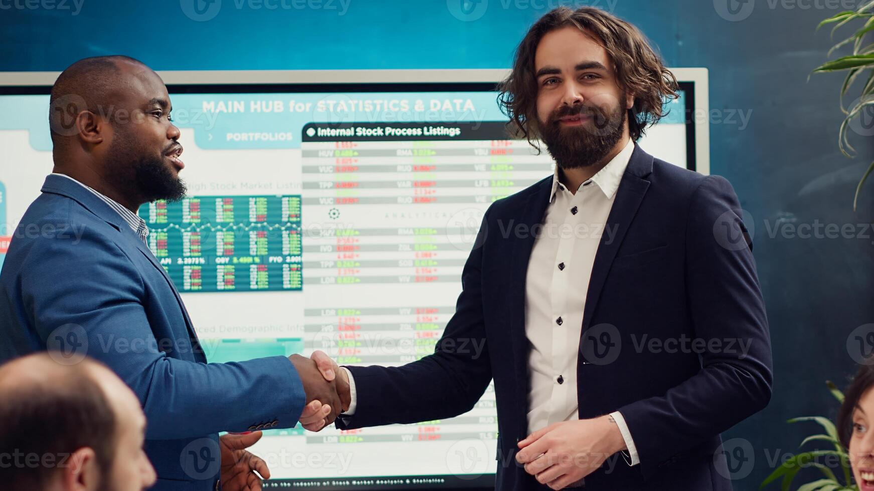 Business partners are shaking hands after establishing a new project between their enterprises. Two managers starting a collaboration to expand organization and increase finances. Camera A. photo