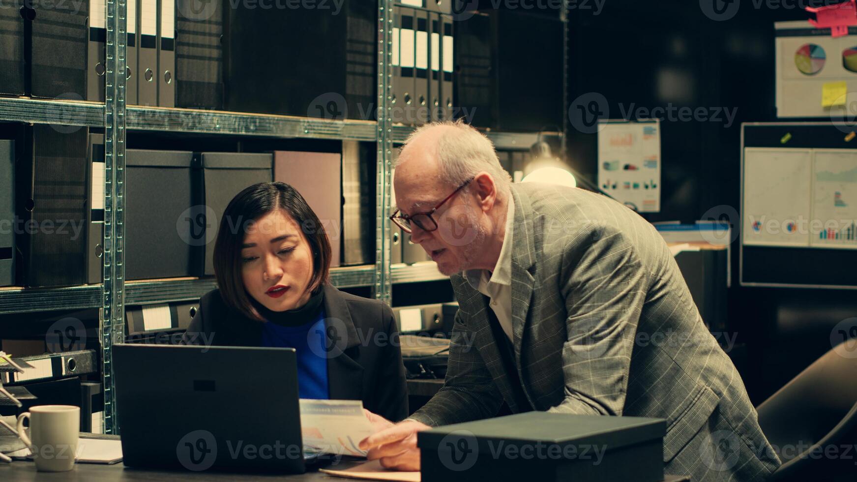 Private investigation team searching for details in case files, analyzing financial records to trace money laundering schemes. Police officers look for clues to catch criminal. Camera A. photo