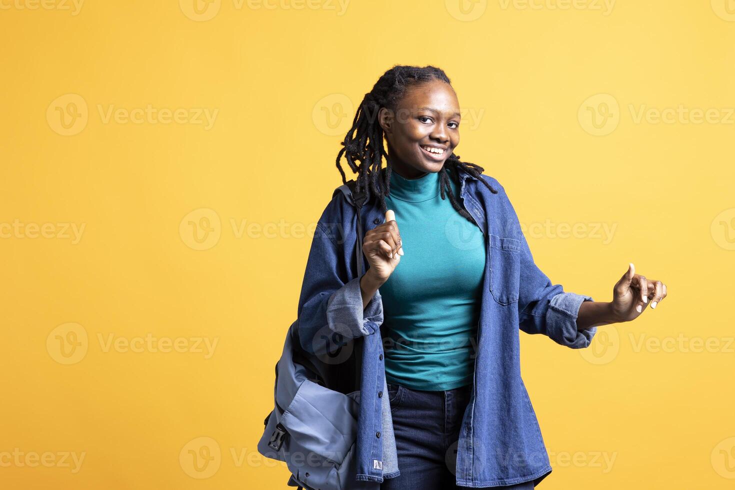 Thrilled african american young girl doing happy dance, feeling joyful, isolated over studio background. Portrait of euphoric woman celebrating achievement, doing positive hand gestures photo