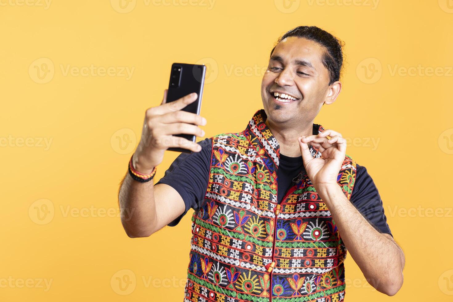 Amused man chatting with funny friend over remote videocall, having fun. Happy person laughing, hearing jokes from mate during videoconference meeting, isolated over studio background photo