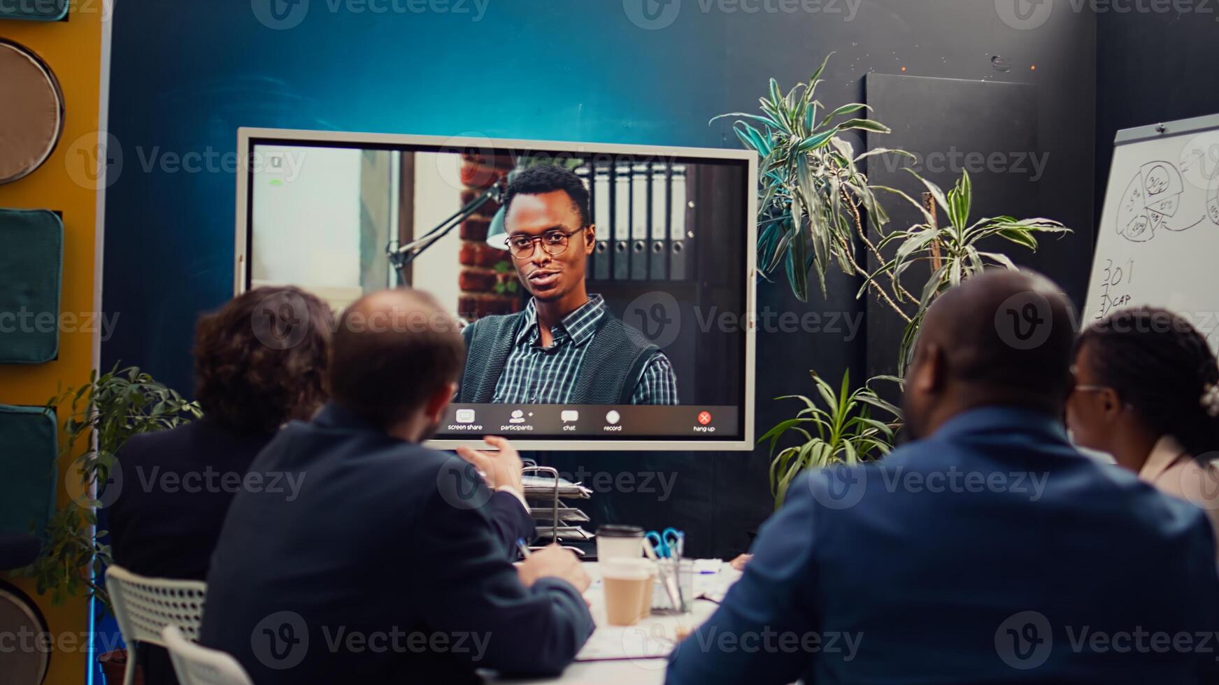 Team attends meeting with the business administrator to present a project briefing, addressing annual data reports and performance metrics via videocall conference online. Camera B. photo