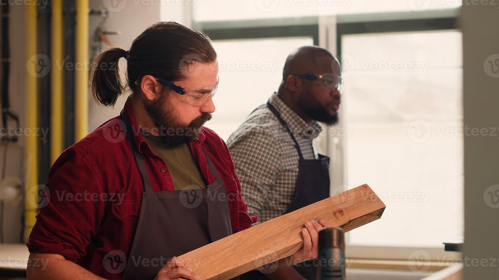 Carpenter selecting quality wood materials, ensuring they align with project requirements. Cabinetmaker doing quality assurance on lumber block in furniture assembling shop, camera A photo