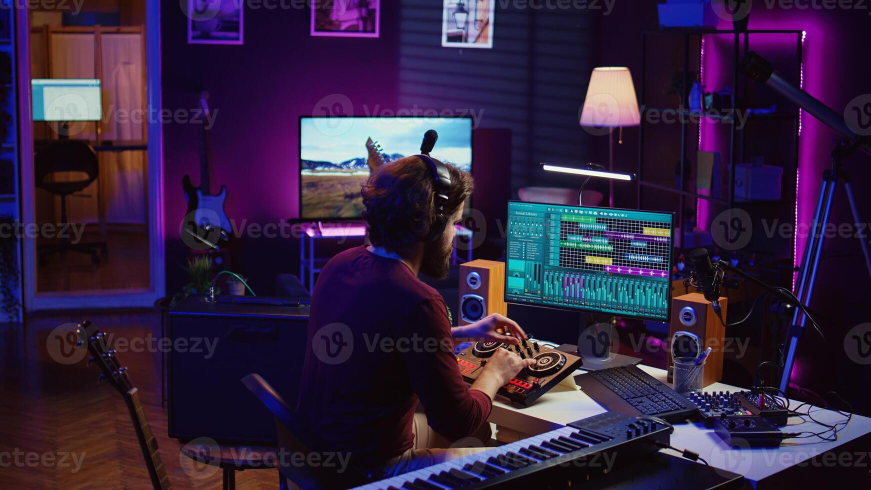 Music producer mixing individual tracks into a stereo in home studio, artist adjusting levels, panning and special effects to achieve a balanced audio. Musician does acoustical engineering. Camera A. photo