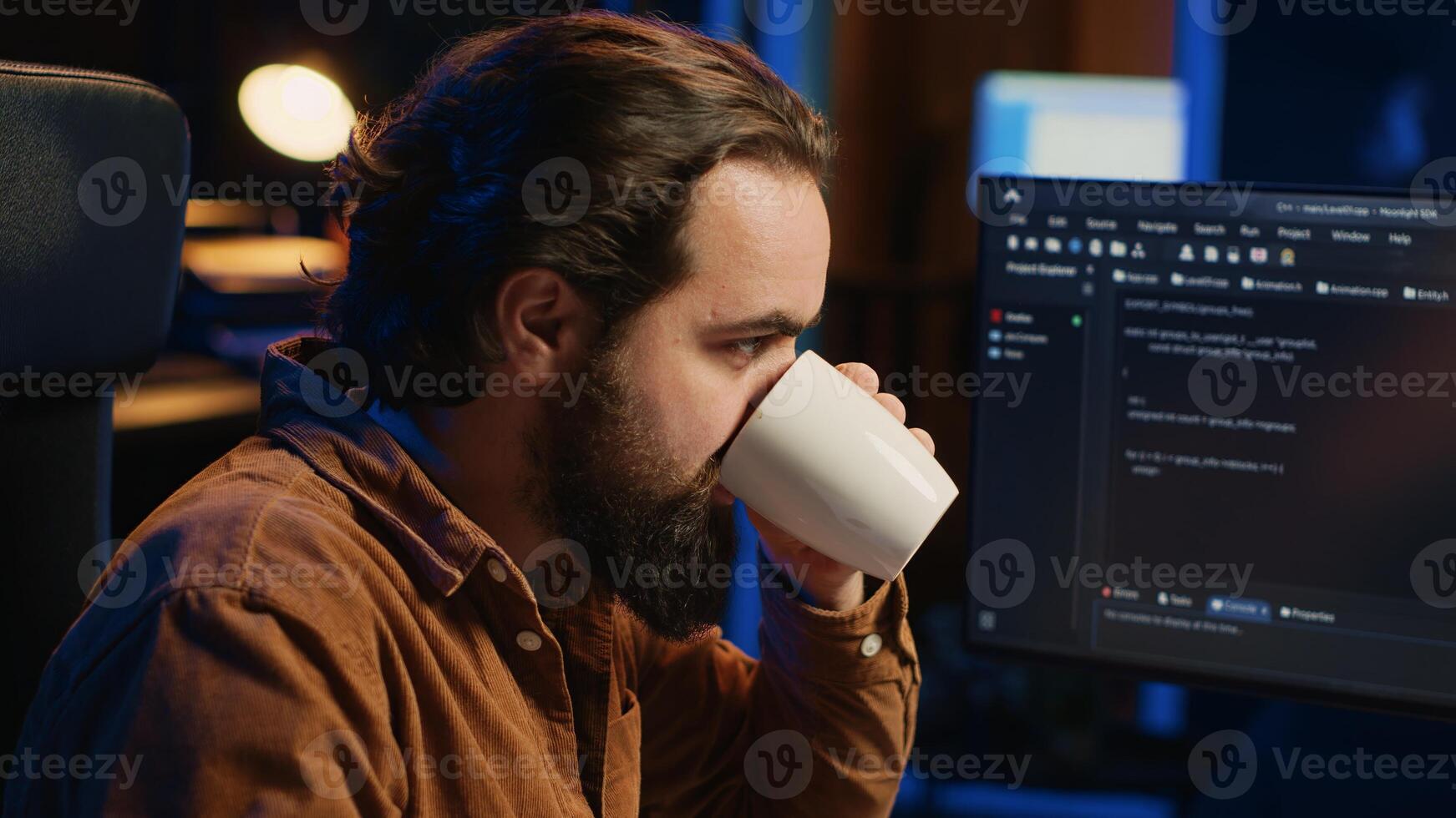 Focused programmer drinking coffee in apartment while solving database errors on computer. Remotely working IT admin concentrated on finalizing coding project in home office, camera A photo