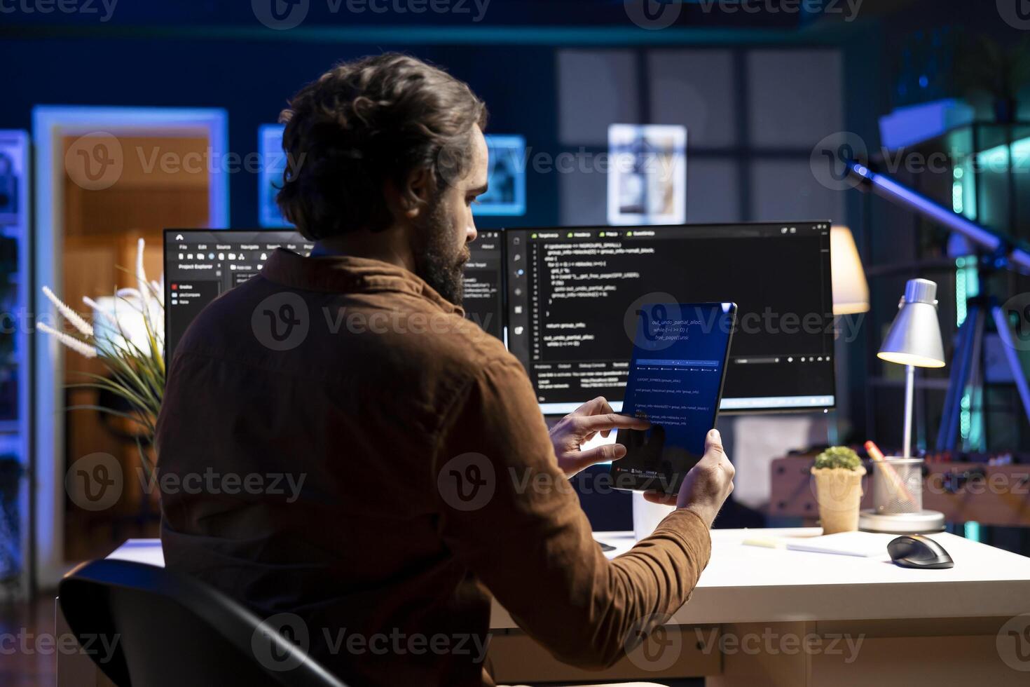 Programmer using tablet to fix vulnerabilities in software enabling attackers to compromise systems. Man taking care of security exposures in operating system, writing code on device photo