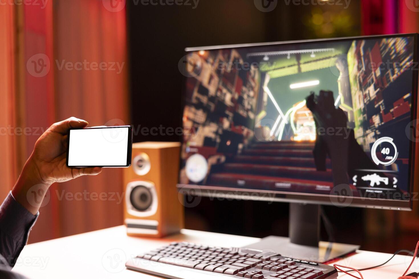 Man watching tutorial on isolated screen phone while playing first person shooter videogame with gun shooting laser bullets. Gamer learning to play game by looking at online guide on mockup cellphone photo