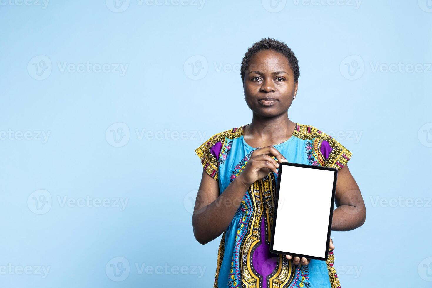 Young adult holding tablet with white display template, doing a marketing ad using blank copyspace layout on modern device. African american girl shows isolated mockup screen. photo