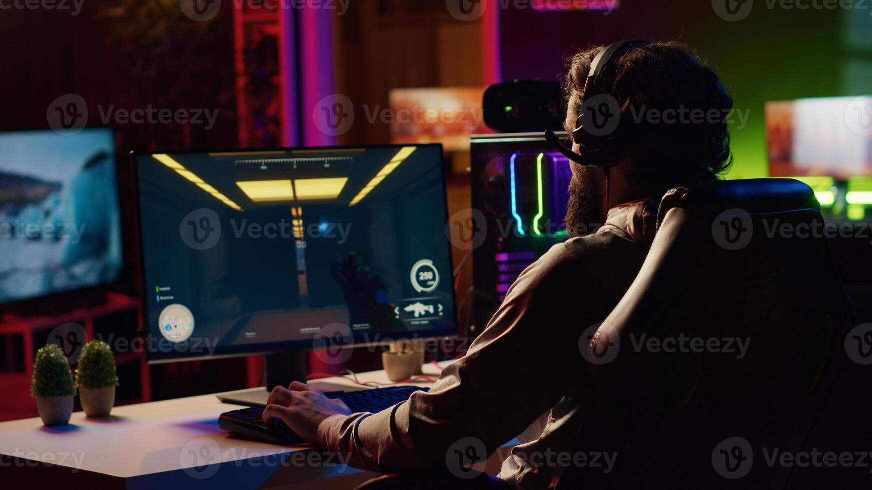 Man coming to gaming station, excited to finally relax by playing SF videogame on PC at computer desk late at night. Gamer starting game, battling foes in online multiplayer futuristic shooter photo
