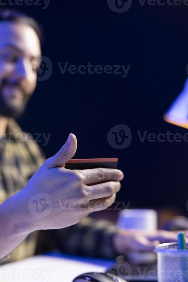 Closeup of man utilizing a laptop for online shopping, making cashless payments with his debit card. Male freelancer conducting internet banking using credit card and portable computer. photo