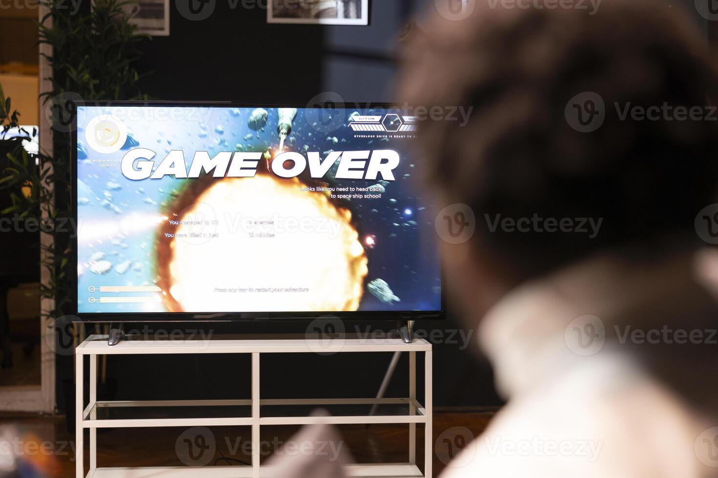 BIPOC gamer feeling gutted after losing singleplayer science fiction videogame level, being outsmarted by enemies. Man at home frustrated after seeing game over screen on smart TV display photo