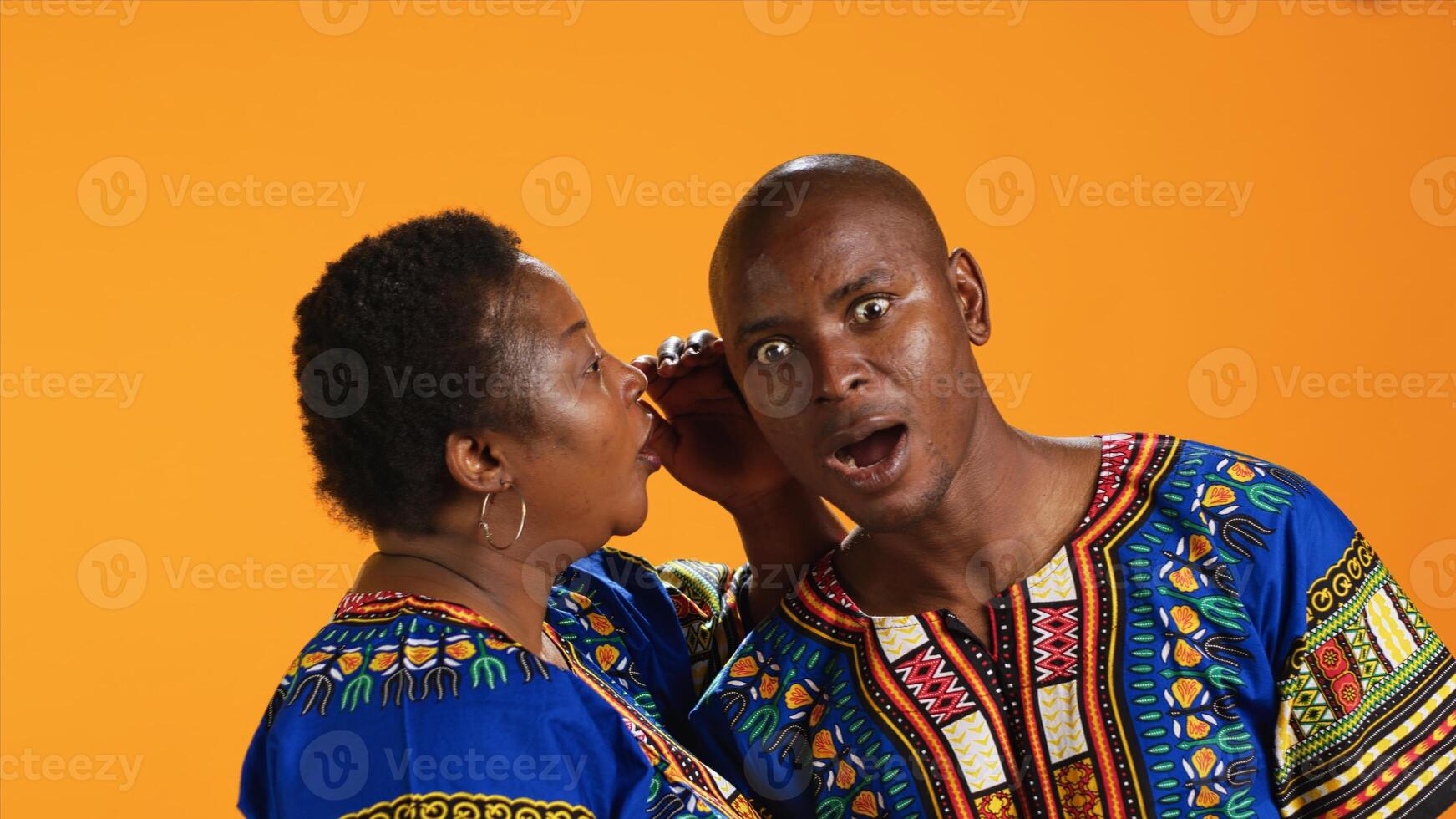Smiling woman sharing important secret with her husband, whispering in his ear and telling gossip. Shocked man leaning in and listening to confidential information, secrecy concept. photo