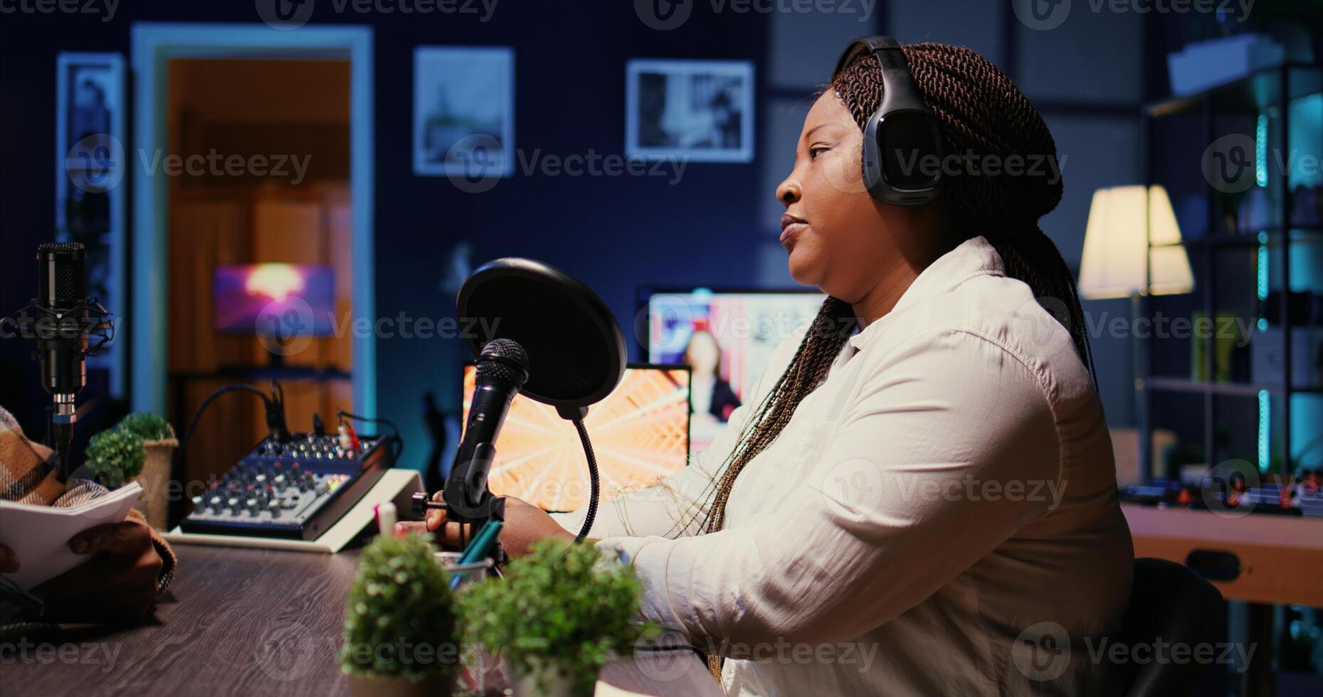 Vlogger show host interviewing guest in neon lights ornate studio, presenting her to audience. Man filming online podcast episode with woman, discussing about personal life, handheld camera shot photo
