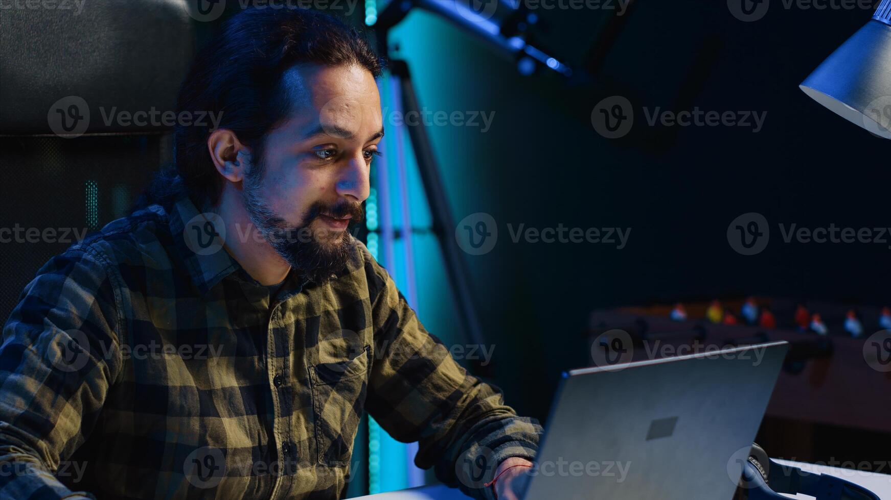 Focused freelancer working from home, typing on laptop, writing in document. Remote employee scrolling on digital device and sending emails to business associates, camera A photo