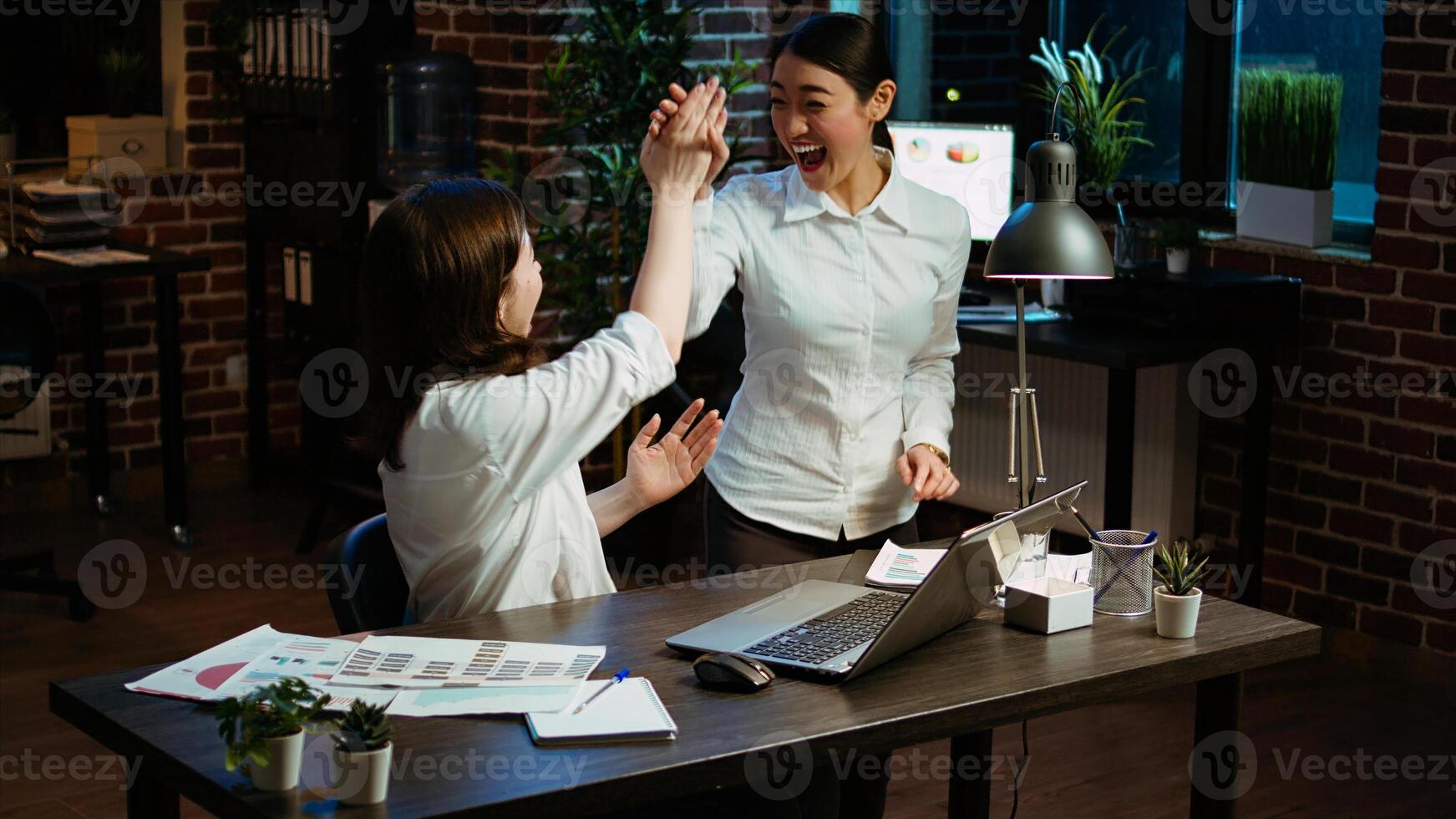 Cheerful coworkers read email on laptop received from customer, excited after managing to secure lucrative deal for company. Colleagues celebrate finalizing agreement with business partners, camera A photo