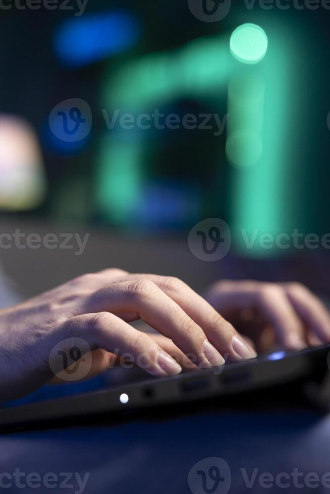 Close up shot of laptop used by teleworker lying on couch, remotely performing tasks in personal home office. Focus on notebook used by man in blurry background inputting data photo